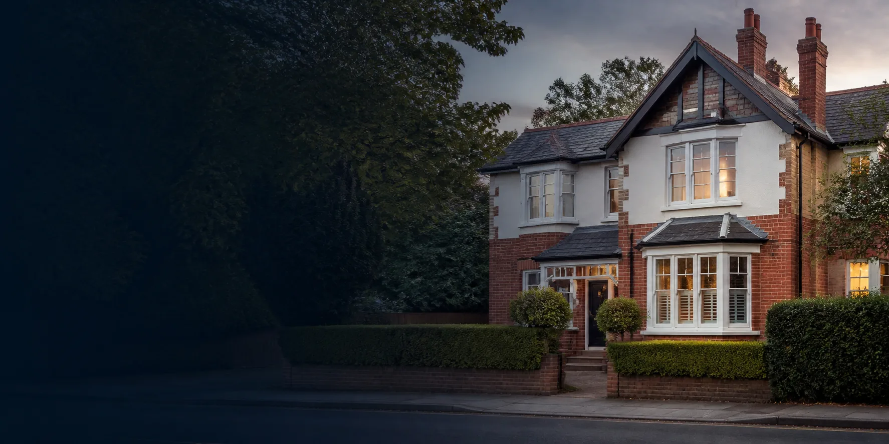 Attractive British family home on a leafy residential street at dusk.