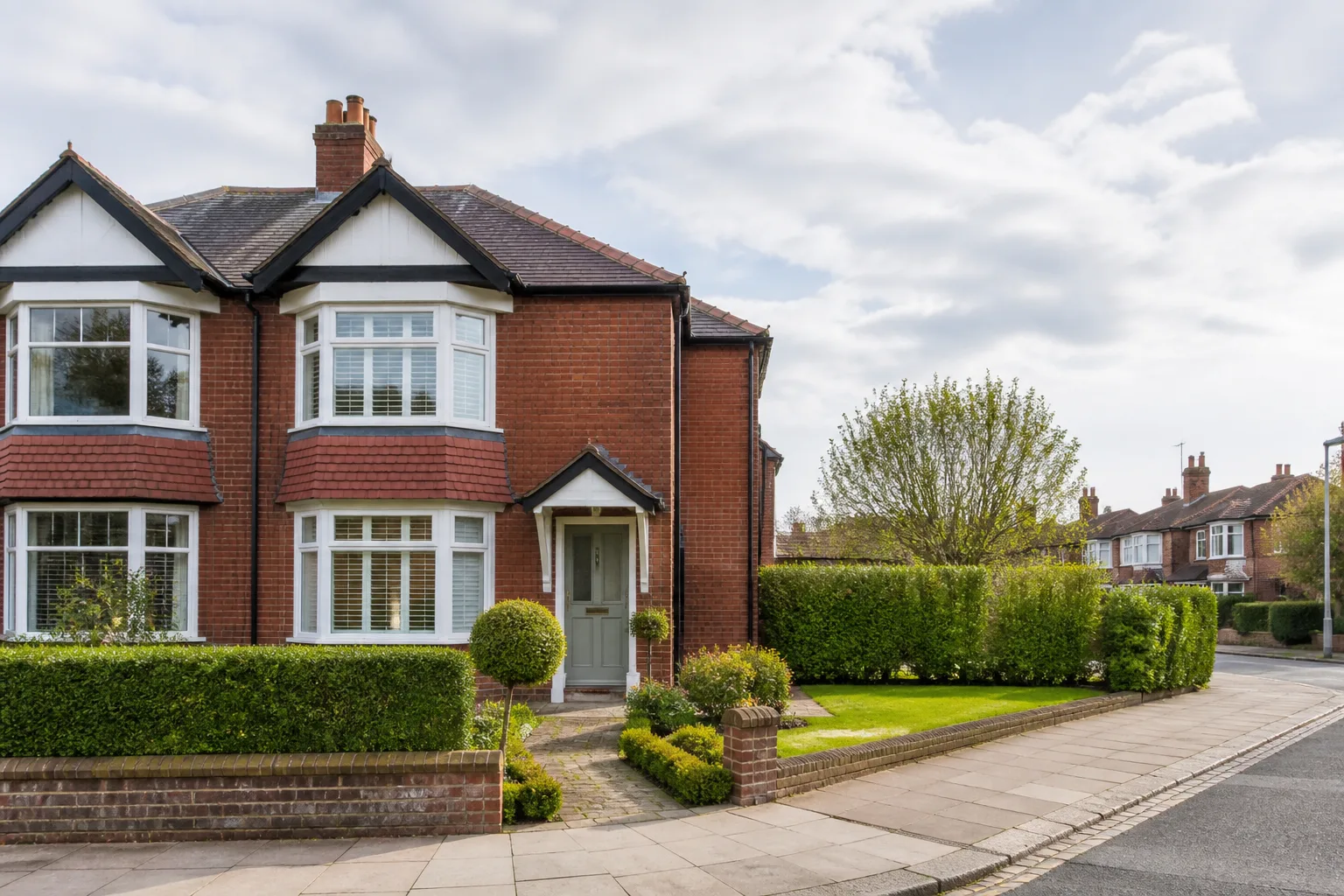 Well-presented British semi-detached home with a tidy front garden on a residential street.